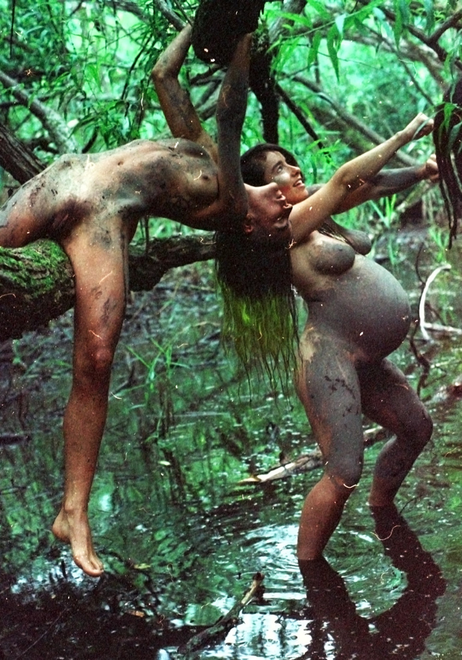 Performers moving through mud and trees in Mud Joy
